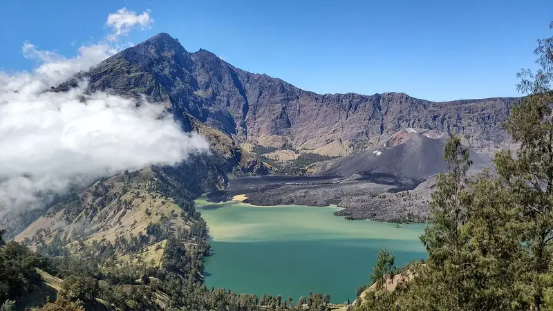Segara Anak lake under the jagged caldera rim, with cloud spilling over the far ridge